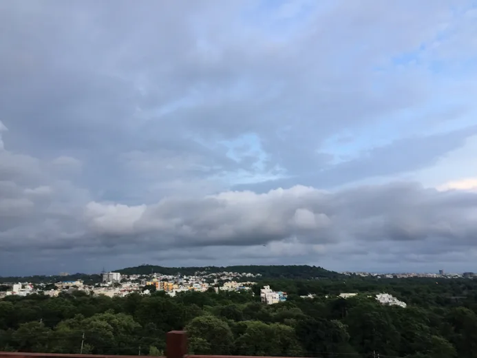 Storm clouds gathering over a distant city skyline
