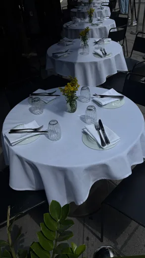 A table set with a white cloth and yellow flowers