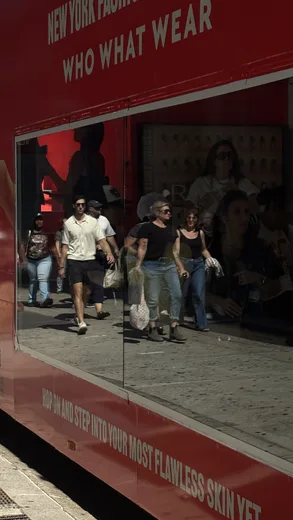 A red storefront window reflecting passers-by