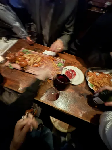 A restaurant table seen from above, covered in food and wine