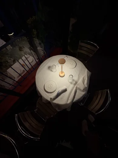 A round table with a small lamp, seen from above in a dark restaurant