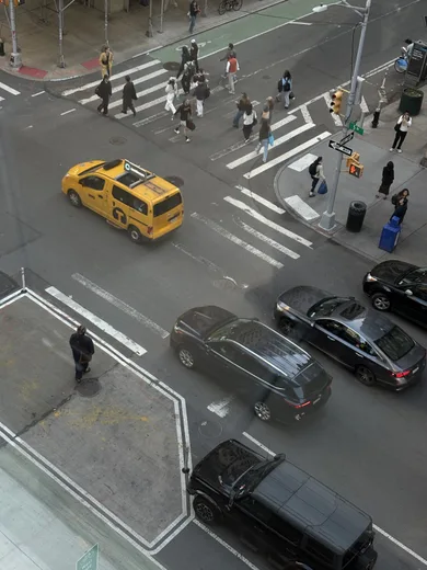 A yellow taxi and pedestrians at a crossing, seen from above