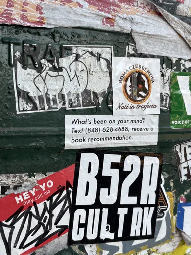 A wall layered with stickers and posters